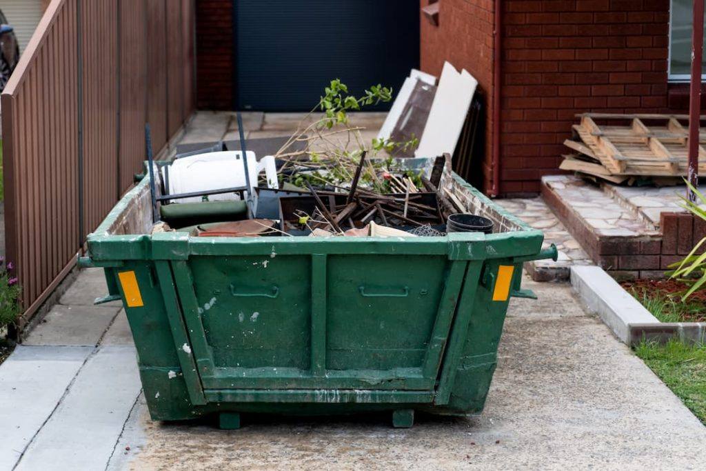 Green Skip Full of Waste Ready to Be Taken Away