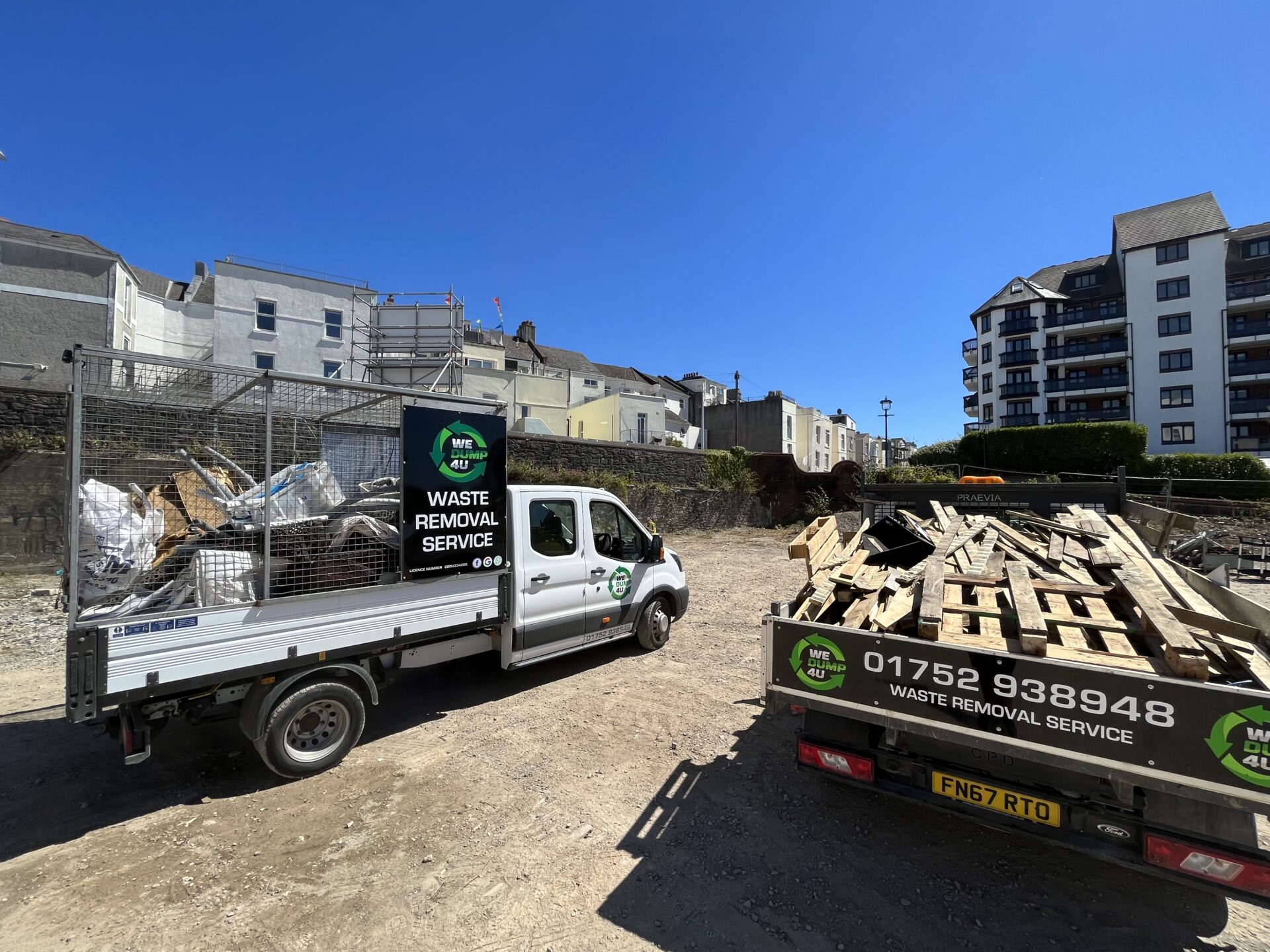 Two we dump for you vans in front of a row of houses